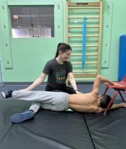 Alex the therapist works with child to help their back