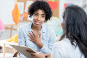 Therapist and Parent sitting at a desk discussing the client